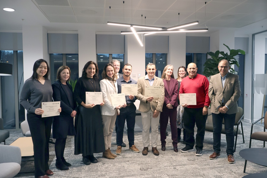 Photo of Baker Hughes participants displaying their certificates alongside module leaders.