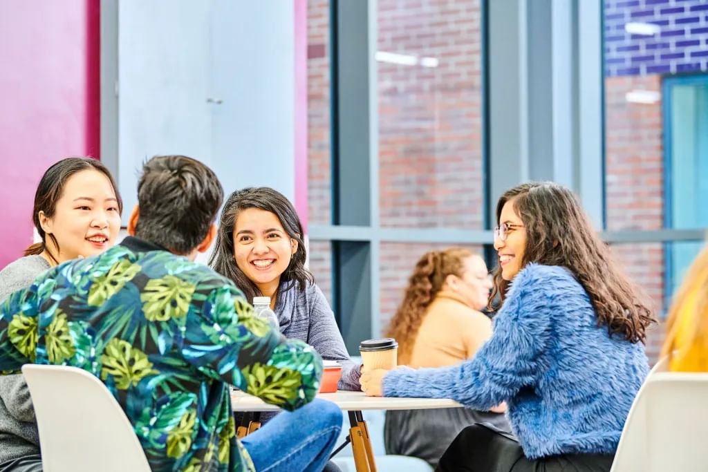 Students sitting together, chatting around a table