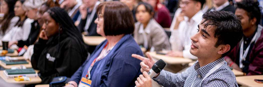 Laidlaw scholar Dillon Shenoy in full lecture theatre with microphone