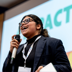 Laidlaw scholar Kunj Kapoor with microphone, presenting at Conference