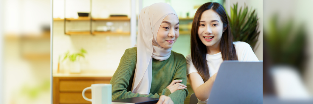 Two female students looking at a laptop screen.