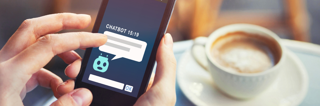 A person with a mobile phone showing a chatbot on the screen.