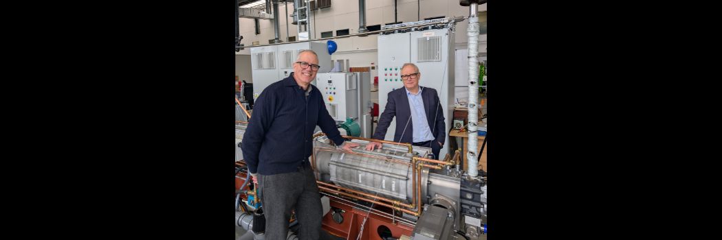 Two men standing with machinery