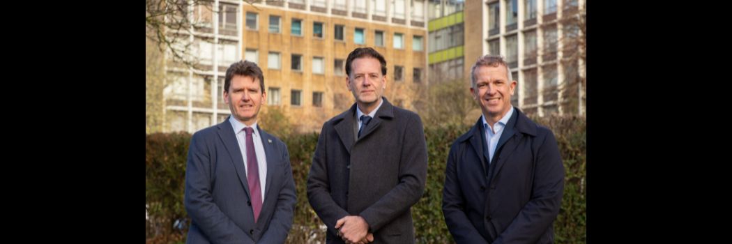 Three men standing in front of office building