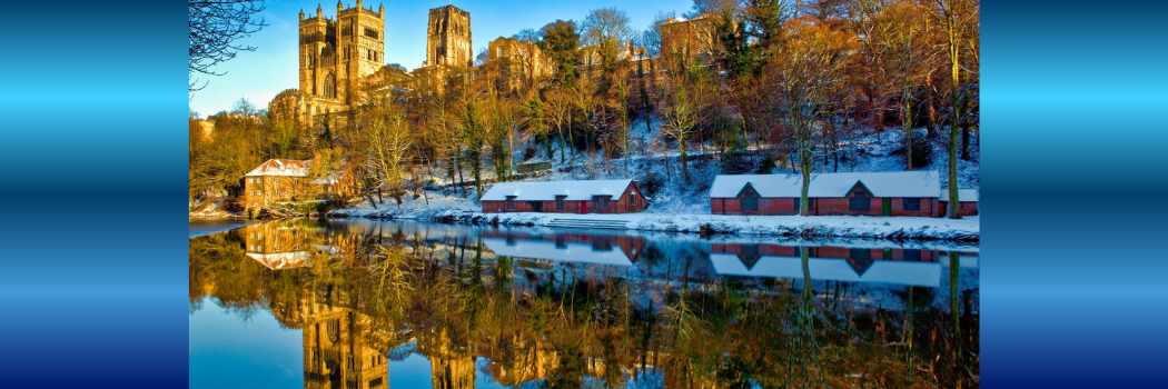 A snowy scene of Durham Cathedral and river, with the sun illuminating the cathedral