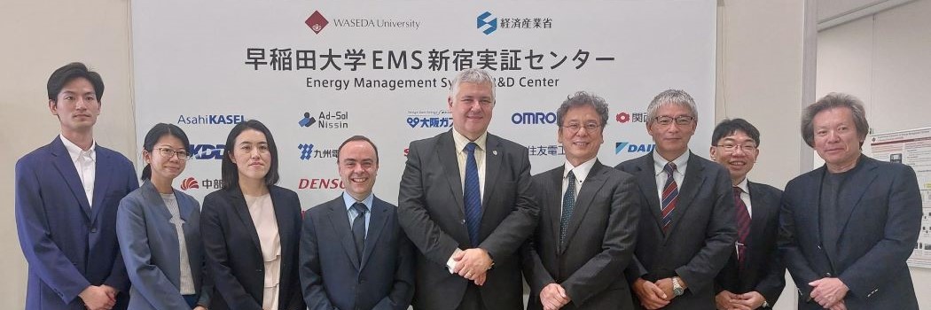 Group of people standing for a photograph in front of a logo backdrop