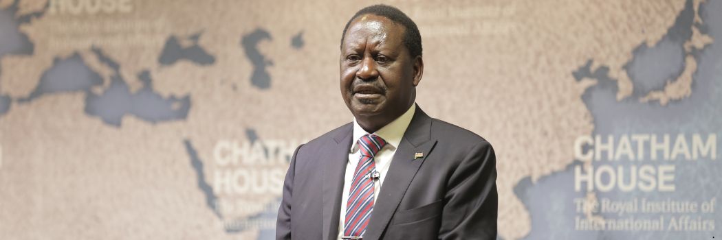 Raila Odinga speaking at an event. He is wearing a suit and tie and standing in front of a backdrop which reads Chatham House.