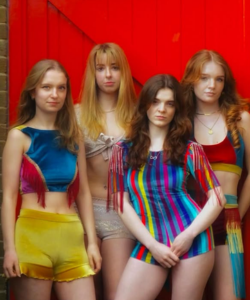 Four students dressed in colourful outfits at their charity fashion show