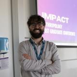 Ahmed Ashqar stands in a Durham University seminar room, smiling at the camera.