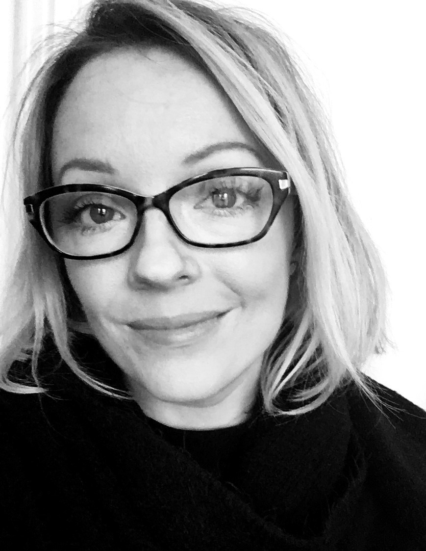 a black and white image of a woman wearing black glasses