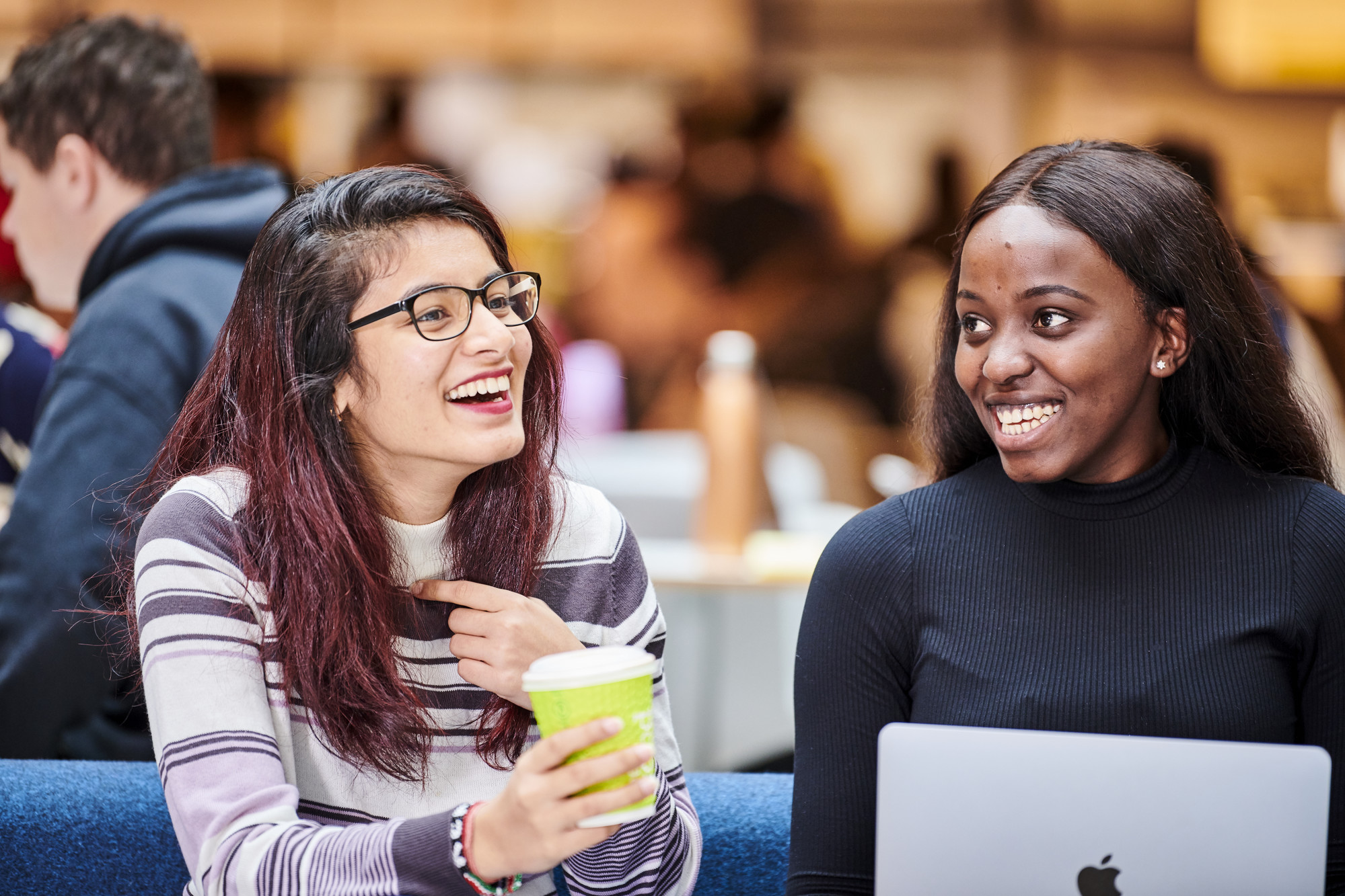 Two students studying in Teaching and Learning Centre with hot drink