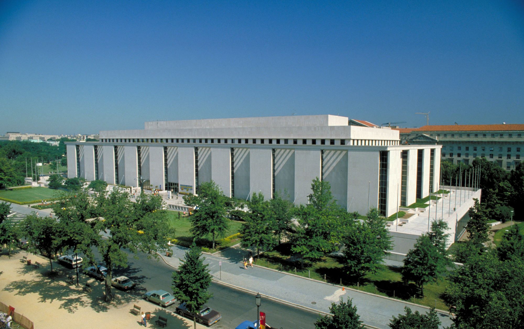 Large white building on a tree lined street
