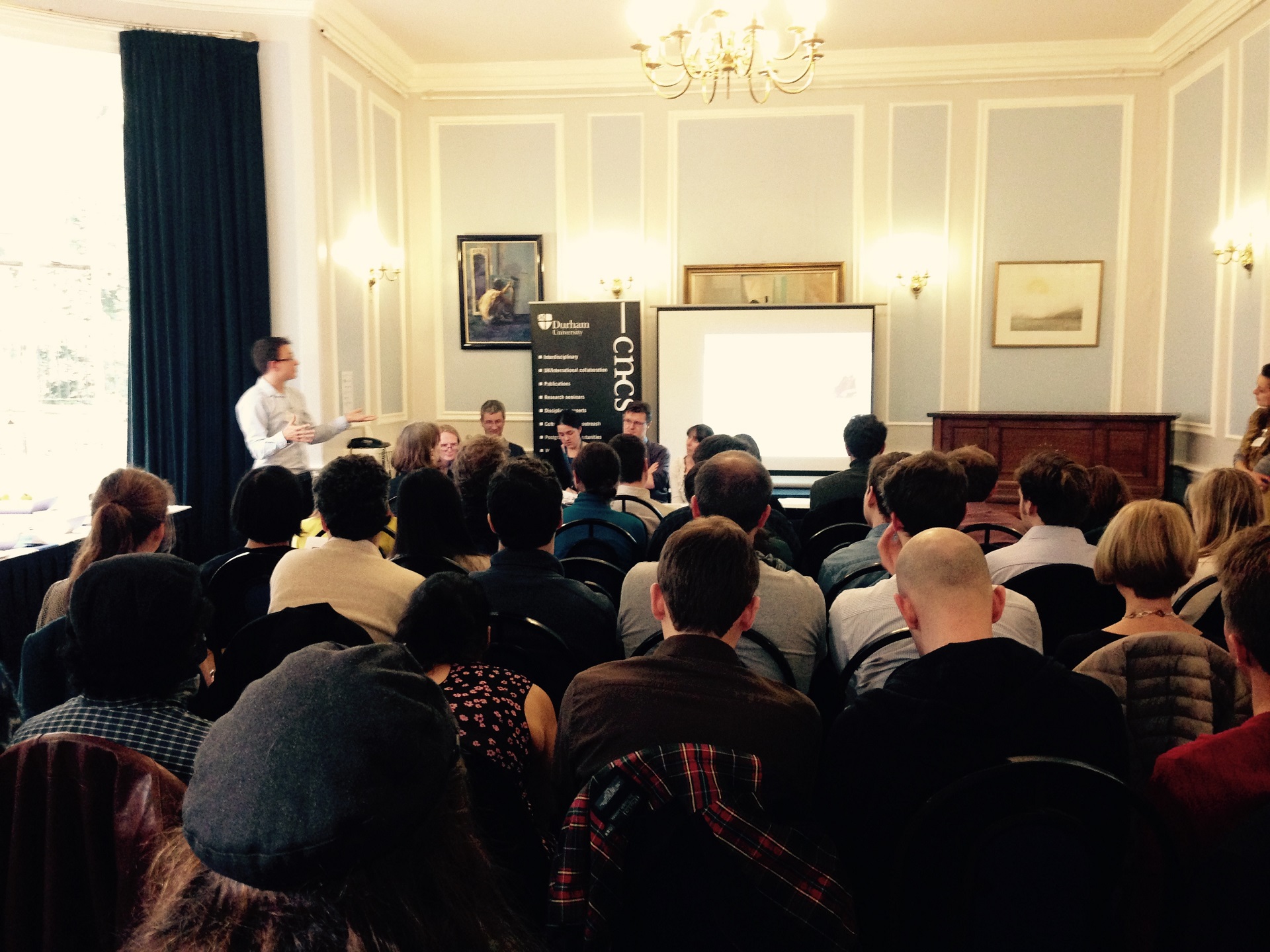 A room full of people watching a presentation