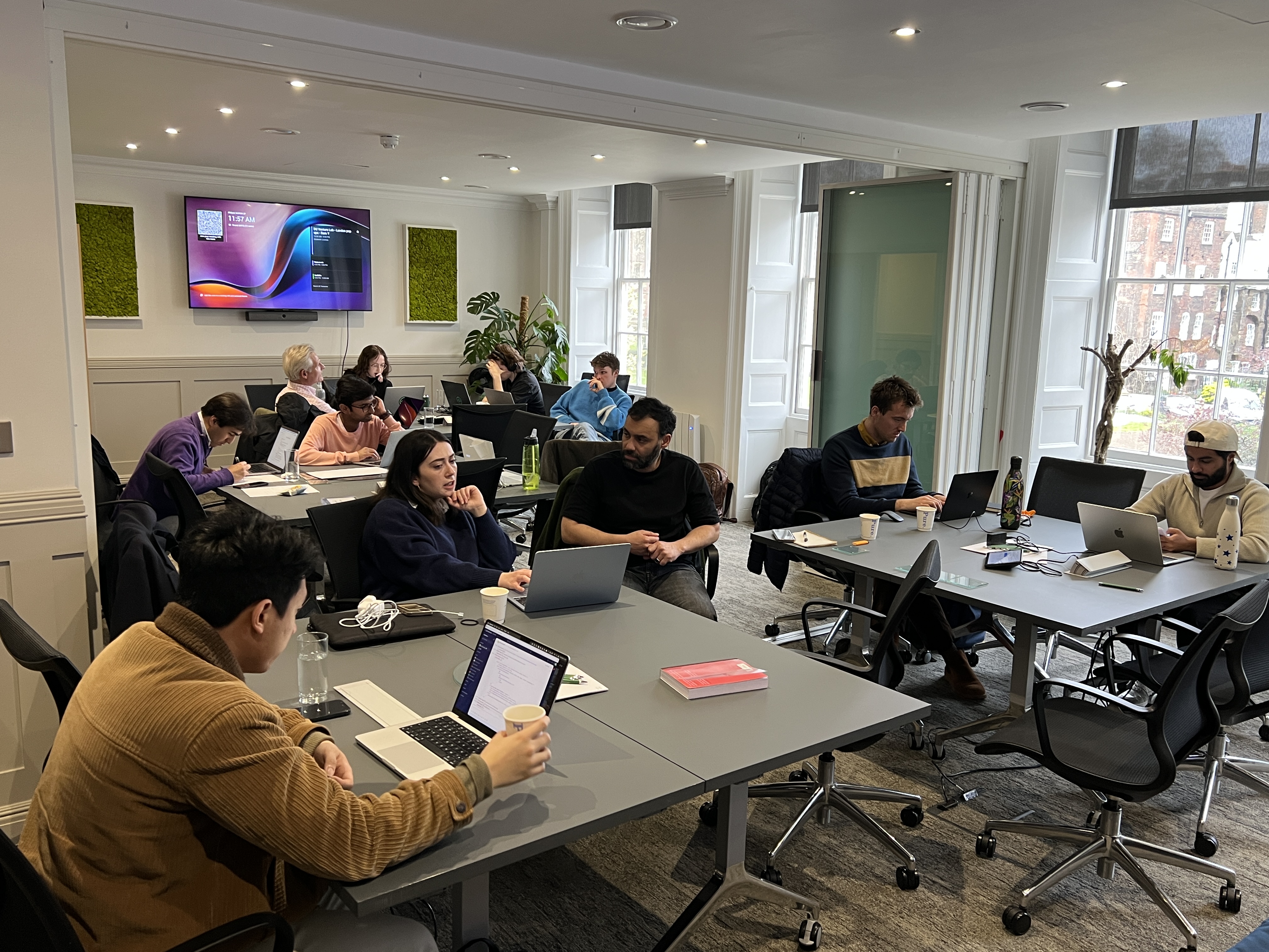 The Venture Lab alumni community co-working at desks in an office
