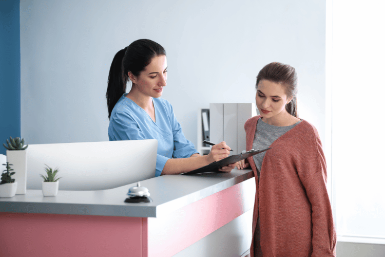 Female healthcare worker holding a clipboard with female patient