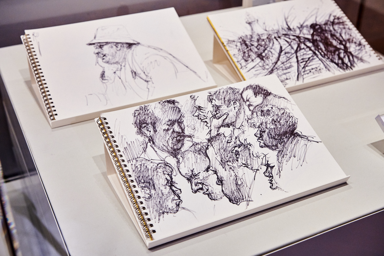 Three black and white Norman Cornish sketches showing various figures and a man walking down a street.